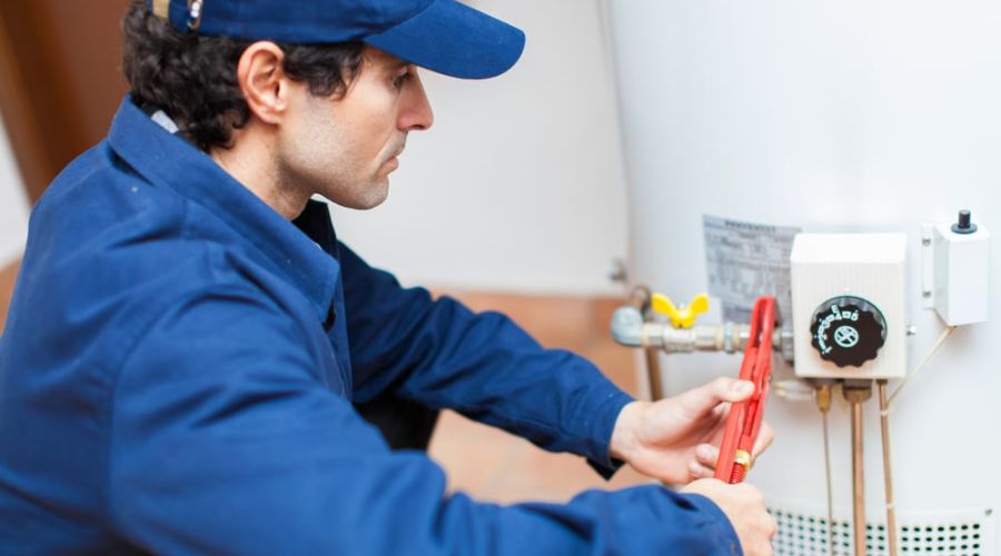 technician repairing water heater